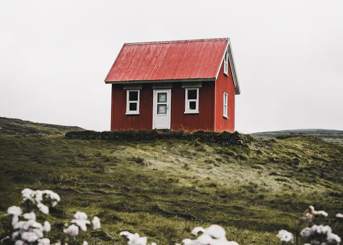 Small red cabin on a grassy hill