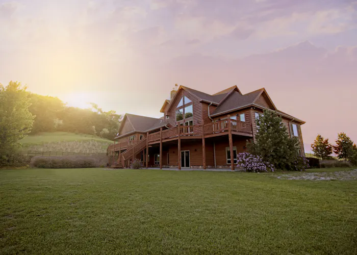 Timber home with wrap-around elevated deck at sunset